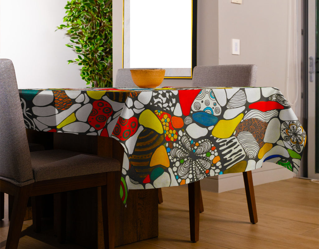 Colorful abstract doodle art tablecloth with bold red, orange, and black patterns on dining table