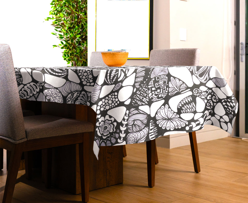 Black and white abstract doodle art tablecloth with floral and geometric patterns on dining table